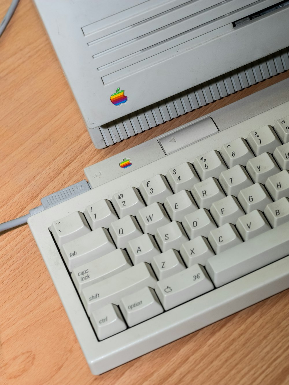 a computer keyboard sitting on top of a wooden desk