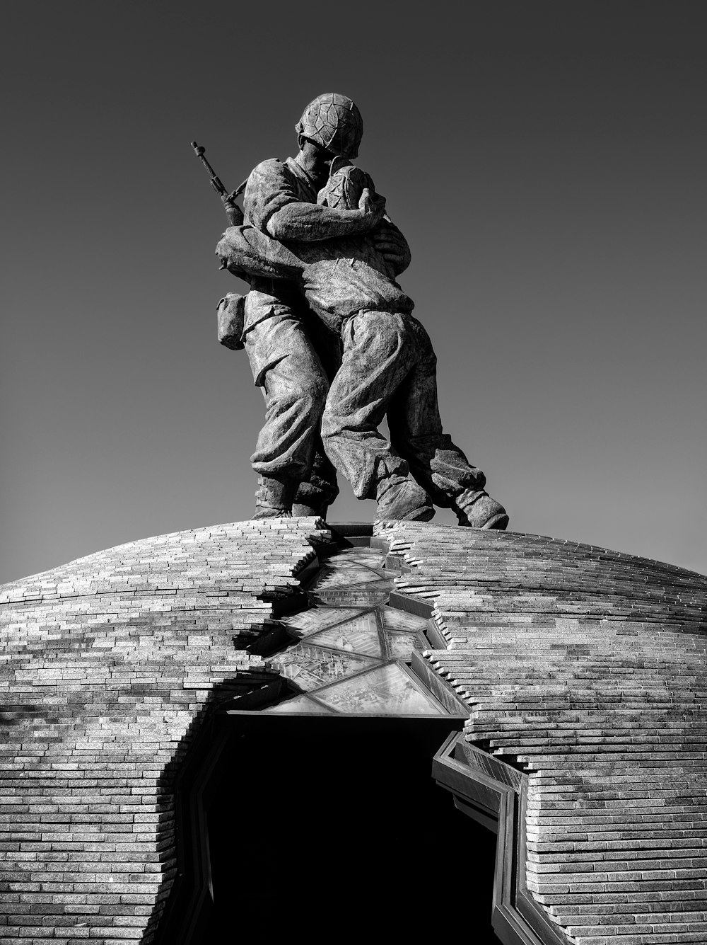 una foto in bianco e nero di una statua in cima a un edificio
