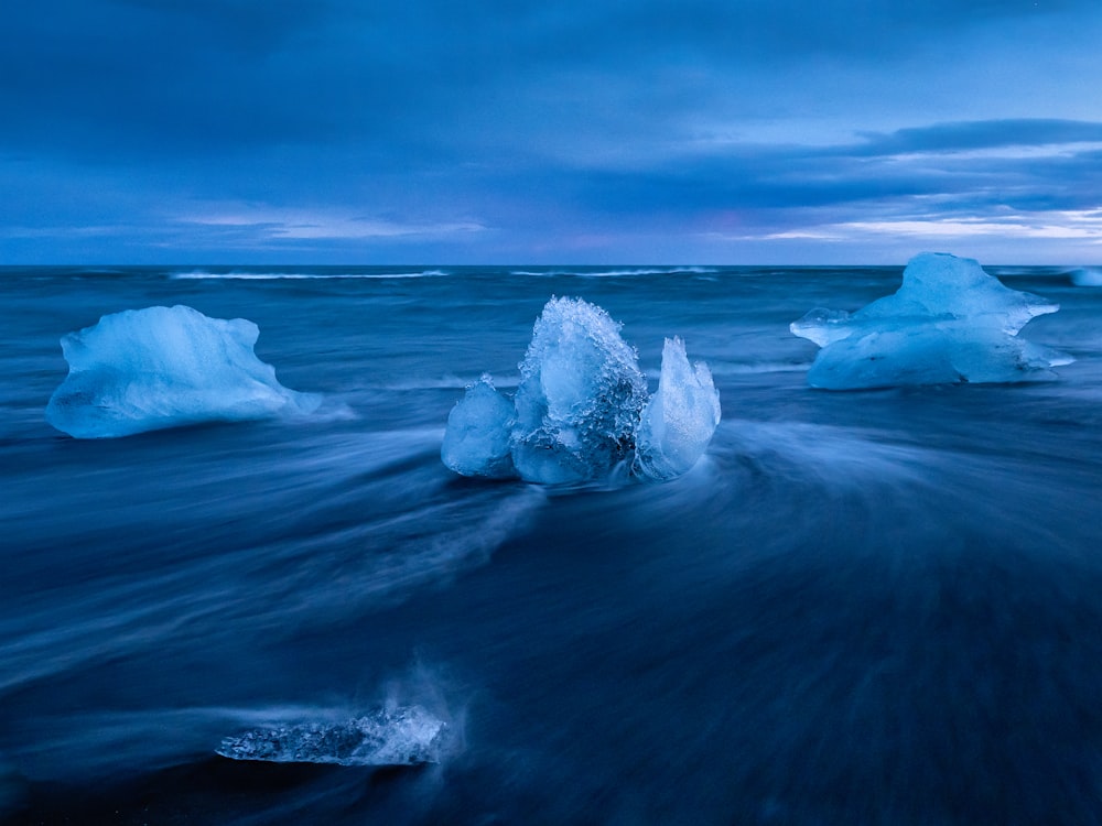 a group of icebergs floating on top of a body of water