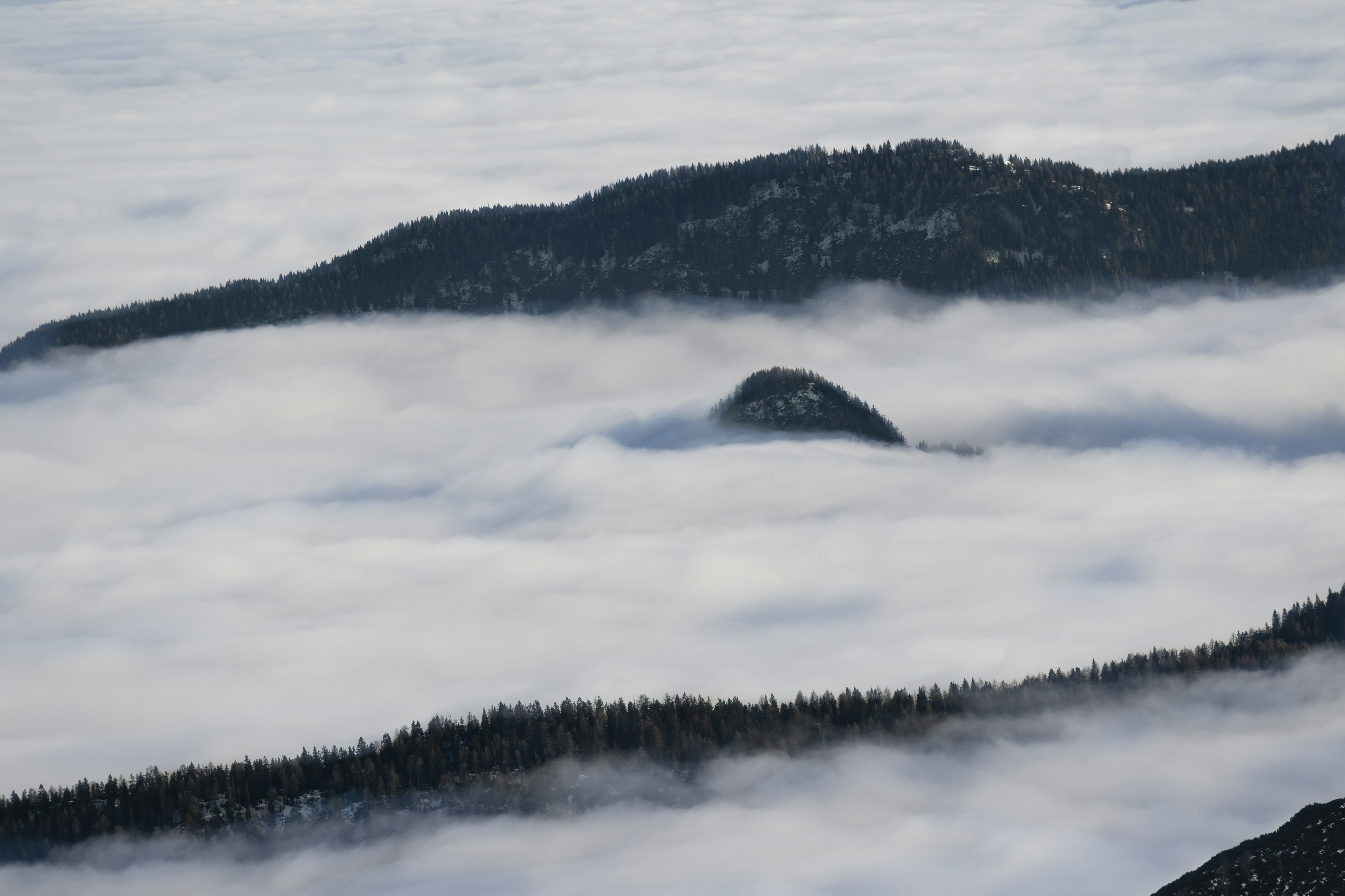 a mountain covered in fog and low lying clouds