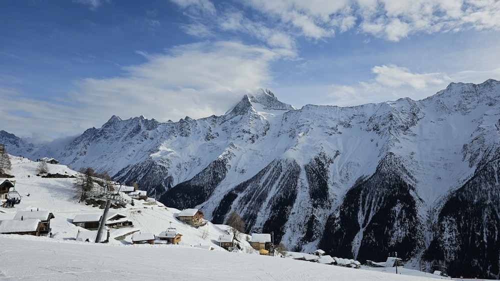 eine schneebedeckte Bergkette mit Häusern darauf
