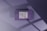 A minimalist card with rounded corners and the letters SRCBCM prominently displayed in large white font on a purple background. Below it, smaller text reads 'Single Rounded Corner Business Card'. Shadows from a window create geometric patterns on the surface.
