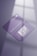 Two purple business cards are placed on a reflective surface. One card is facing up showing a stylized white text and the other is facing down displaying a QR code and details in white. The lighting creates soft shadows and a subtle window reflection on the surface.