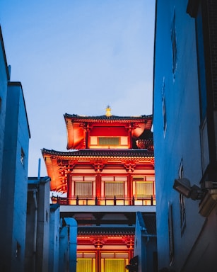 a tall building with a red roof next to tall buildings