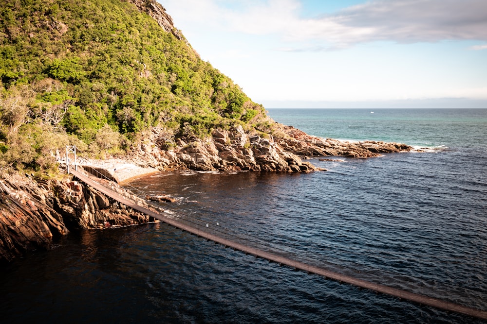 a large body of water next to a lush green hillside