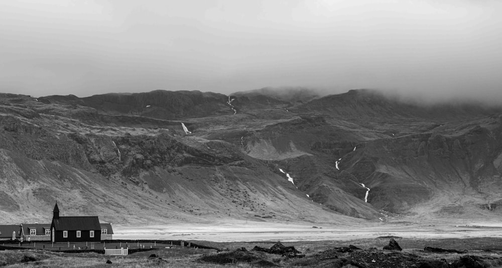 a black and white photo of a house in the mountains