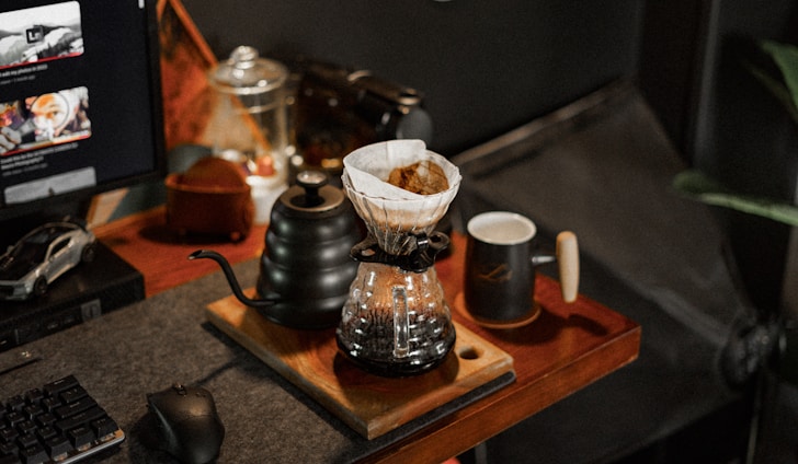 A cozy workspace with open power plant manuals and a steaming cup of coffee.