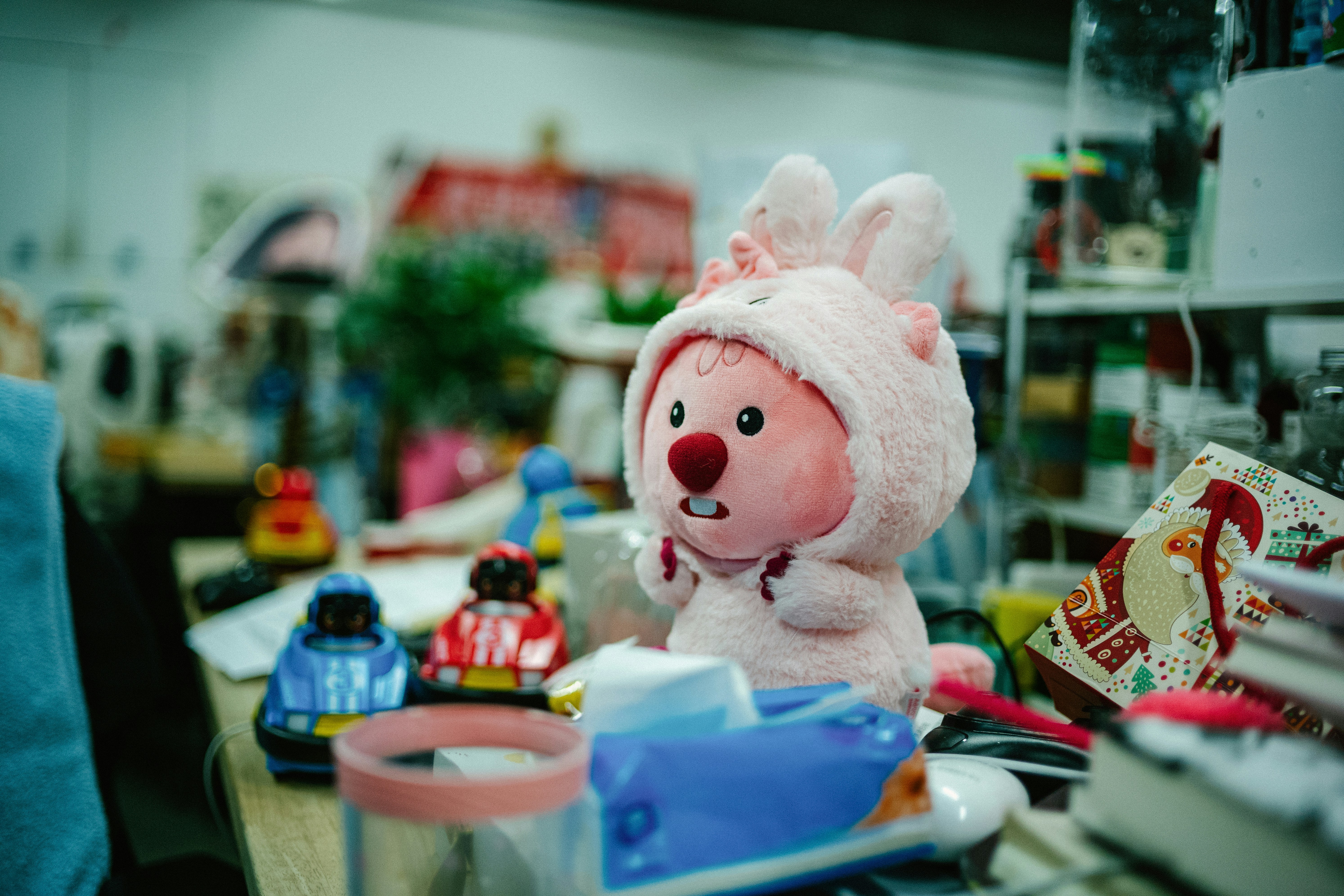 a pink stuffed animal sitting on top of a wooden table (Photo by tommao wang on Unsplash)