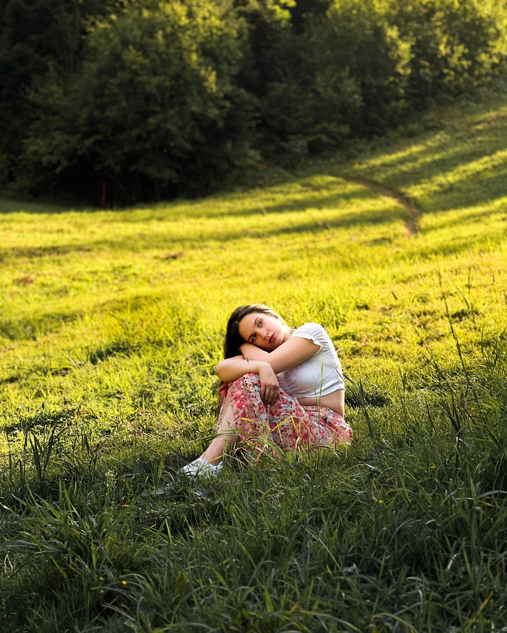 a woman sitting in a field of green grass