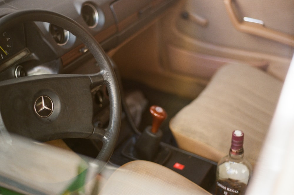 a bottle of alcohol sitting in the driver's seat of a car