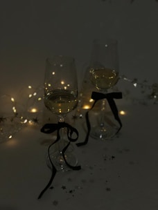 Decorative wine glass charms hanging from delicate wine glasses at a festive gathering.