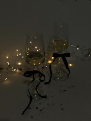 Decorative wine glass charms hanging from delicate wine glasses at a festive gathering.
