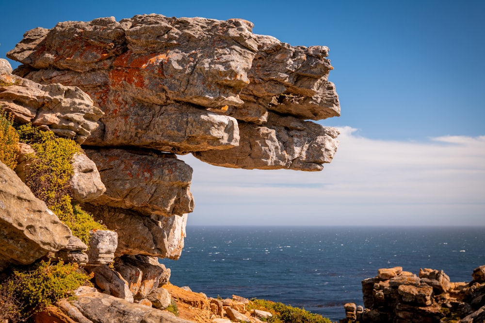 a large rock formation with a body of water in the background