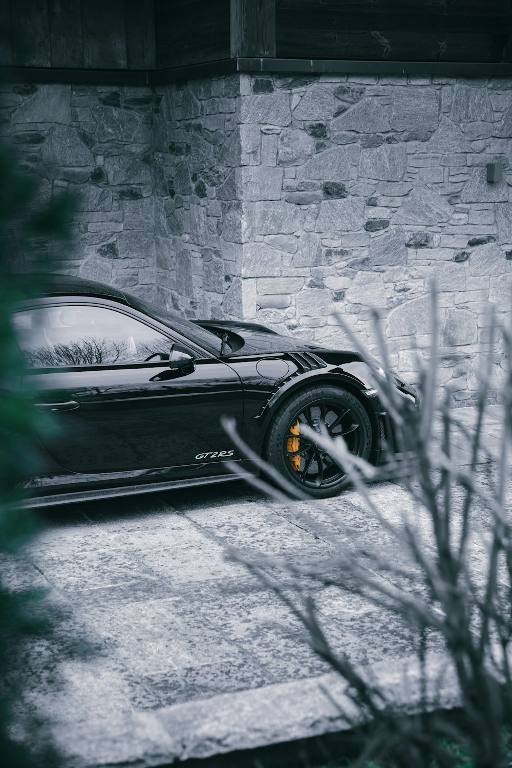 a black sports car parked in front of a stone building