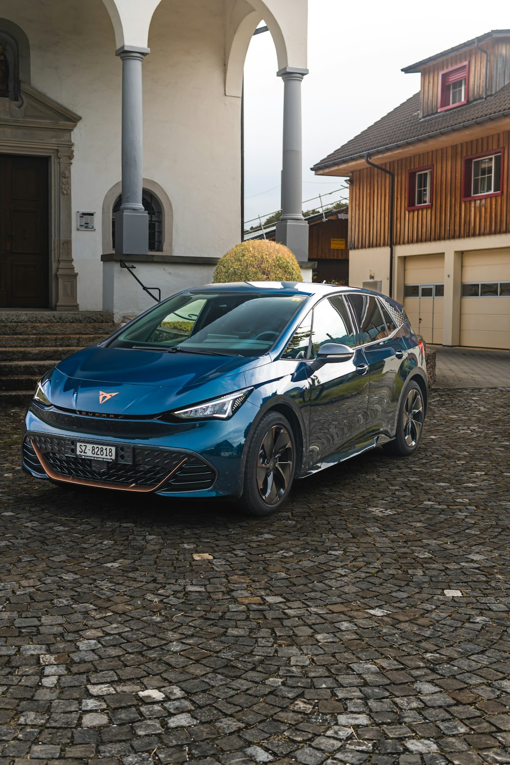 a blue car parked in front of a house