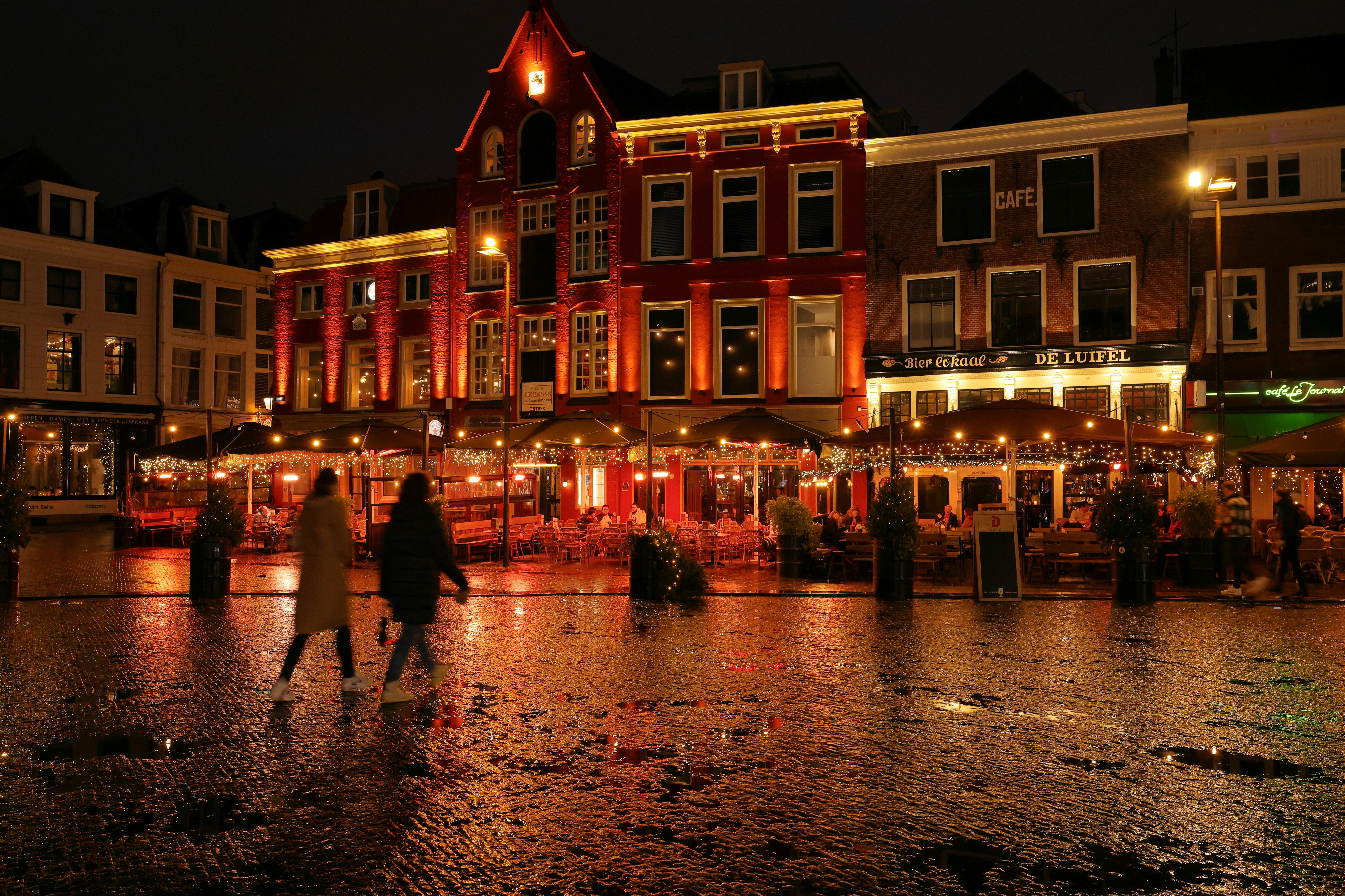 a couple of people that are standing in the rain