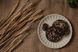 Close-up of golden wheat and ragi cookies stacked on a rustic wooden board.