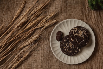 An inviting plate of golden wheat cookies and soft buns arranged on a wooden table.