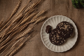 An inviting plate of golden wheat cookies and soft buns arranged on a wooden table.