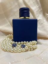 Elegant perfume bottle with royal blue and gold accents on a white background.