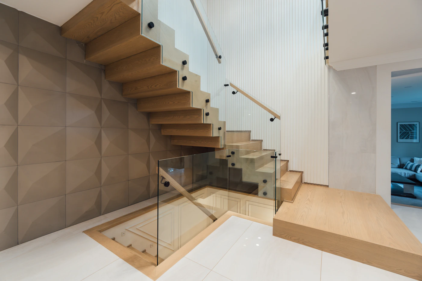 Contemporary stair railing made of clear glass with wood handrail