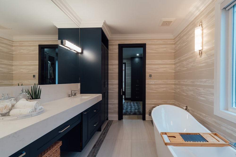 a bathroom with a tub, sink, and large mirror