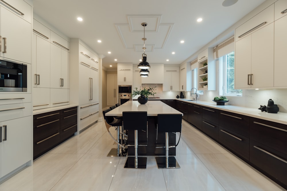 a large kitchen with a center island and white cabinets