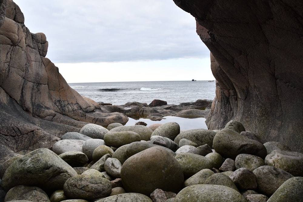 a rocky beach area with large rocks and a body of water