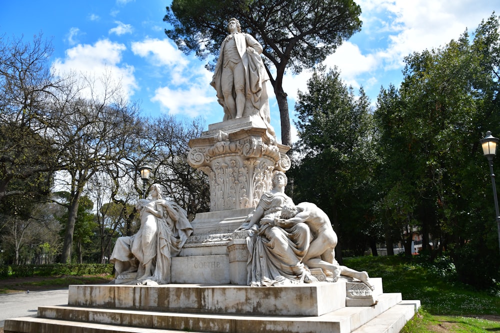 a statue in a park with trees in the background