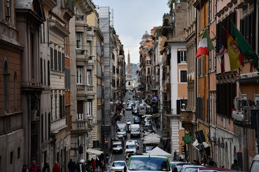 A vibrant street in Italy with students walking and historic buildings in the background.