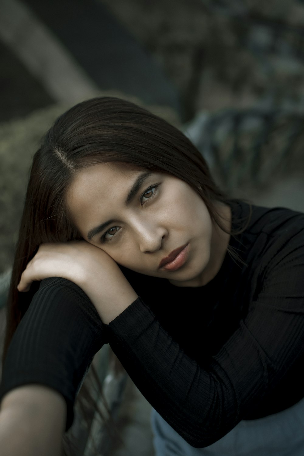 a woman sitting on a bench with her hand on her head