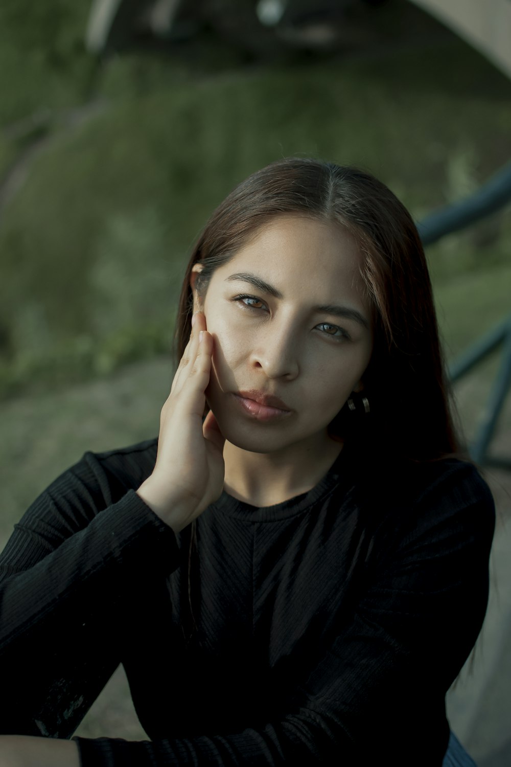 a woman sitting down with her hand on her face