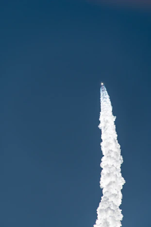 a jet flying in the sky leaving a trail of smoke