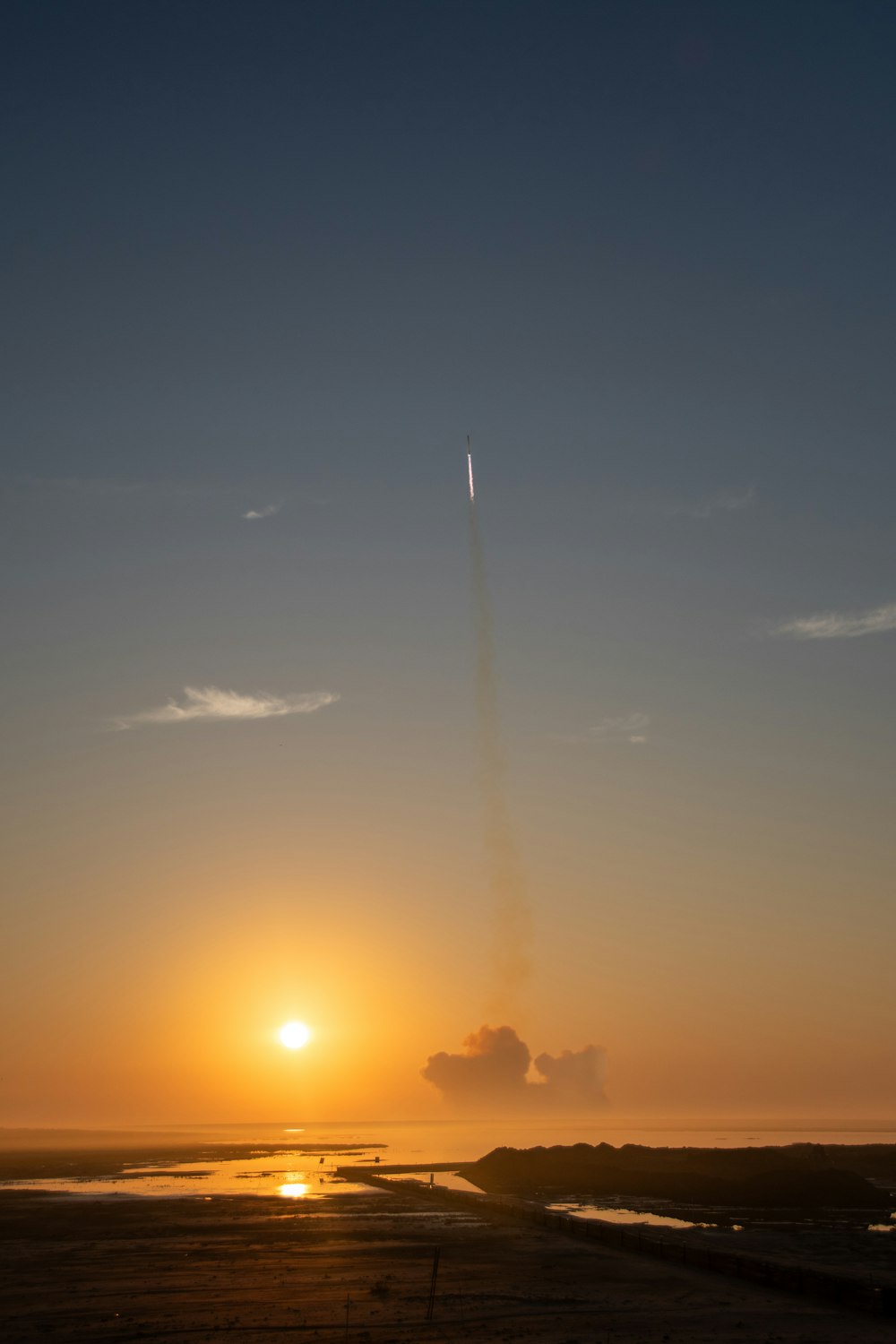 a jet flying in the sky at sunset