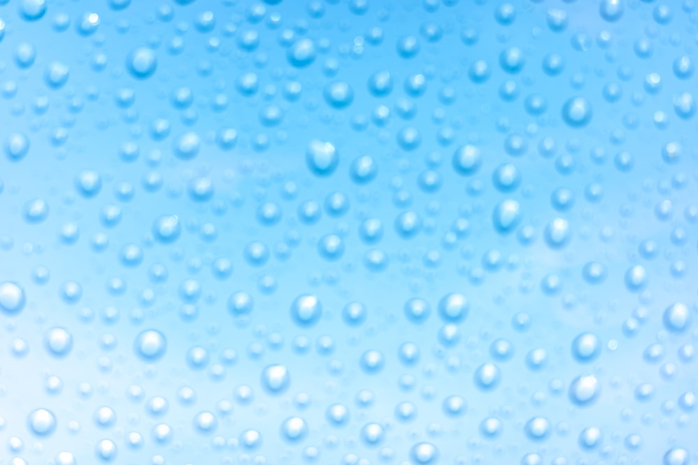 a close up of water droplets on a blue background