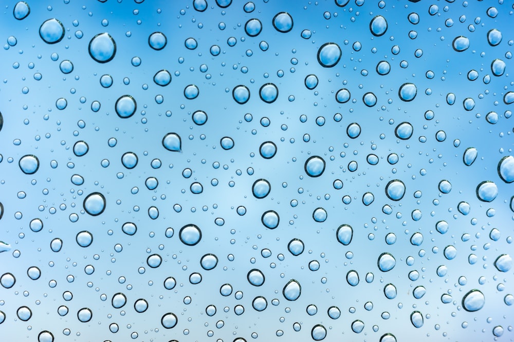 water drops on a window with a blue sky in the background