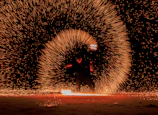 A magical fire performance illuminating a night festival with warm glowing embers