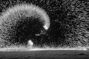 A dazzling fire dancer performing under a starlit sky, captivating the audience.