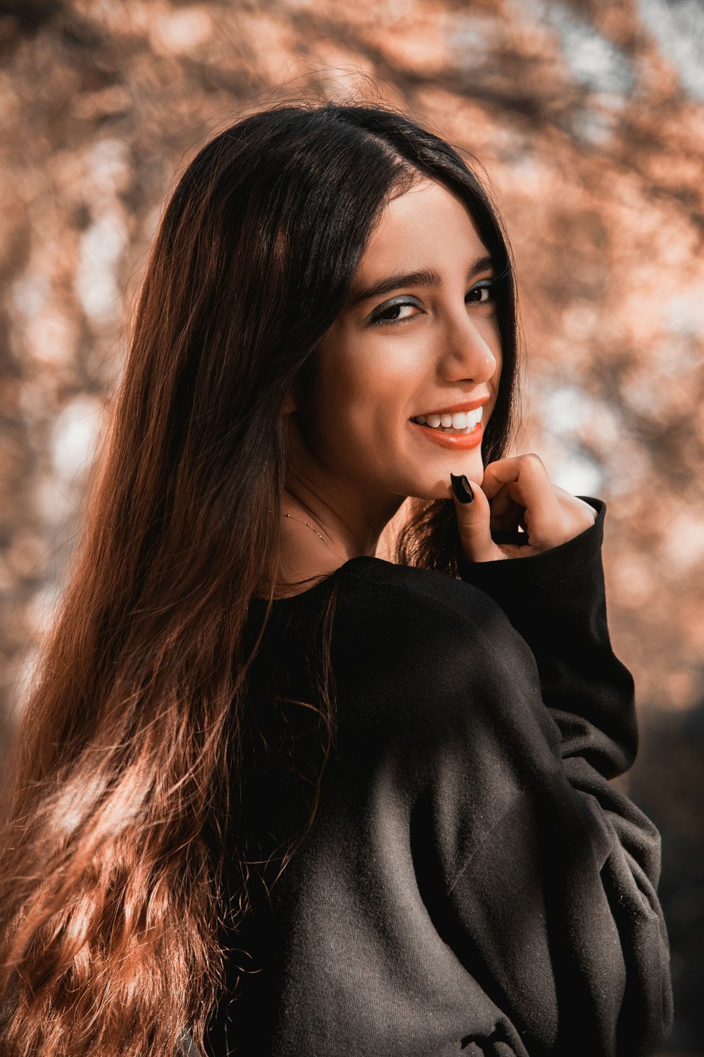 a woman with long hair is smiling at the camera