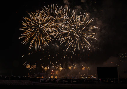 Wide-angle view of the bustling fireworks factory floor with workers assembling vibrant cakes and rockets.
