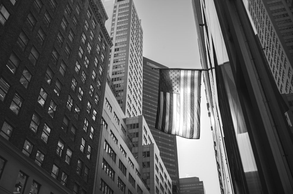 a black and white photo of a flag hanging from a building