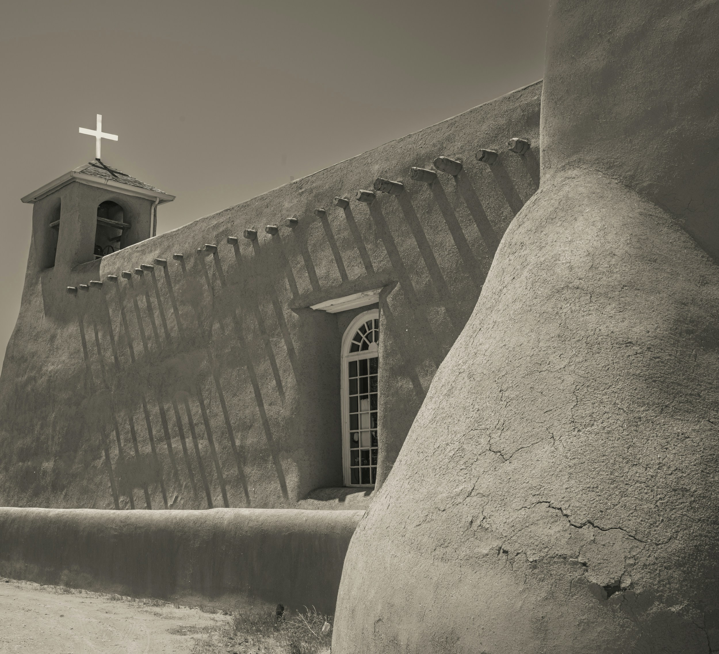 a black and white photo of a church with a cross on top