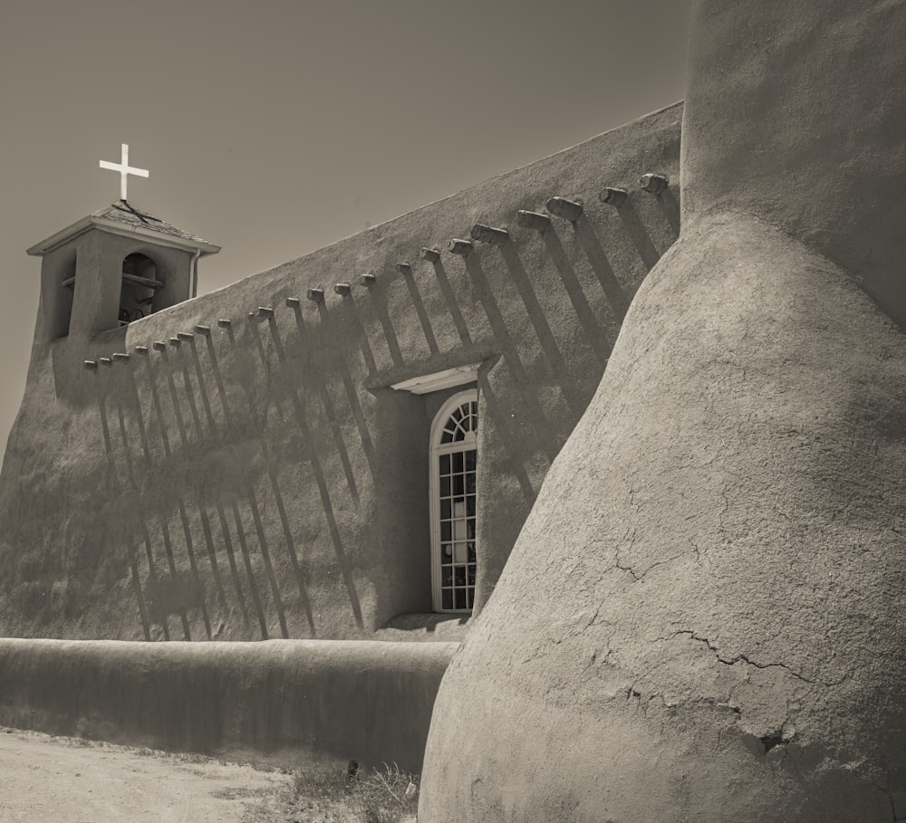 a black and white photo of a church with a cross on top