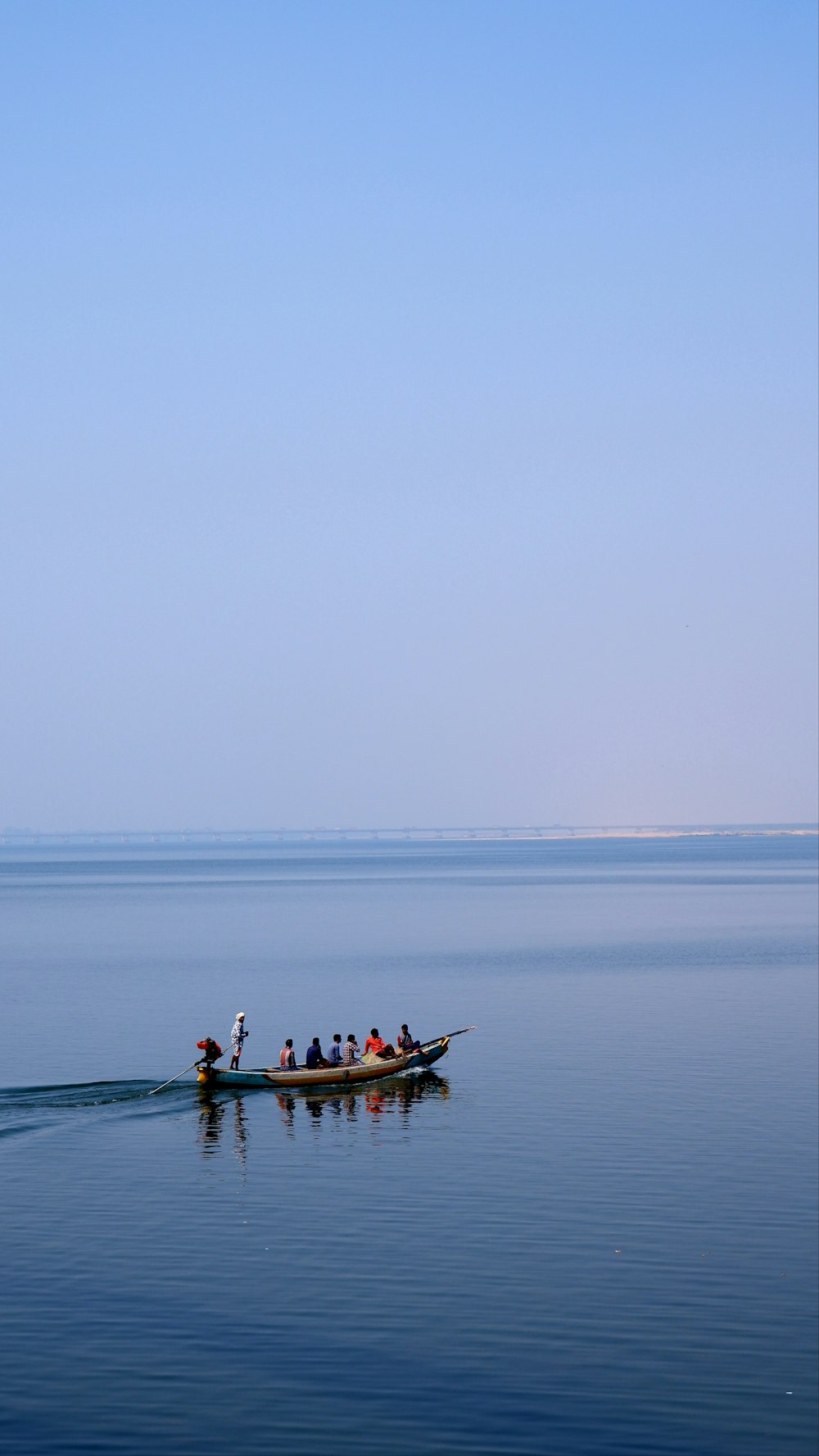 eine Gruppe von Menschen in einem kleinen Boot auf einem großen Gewässer