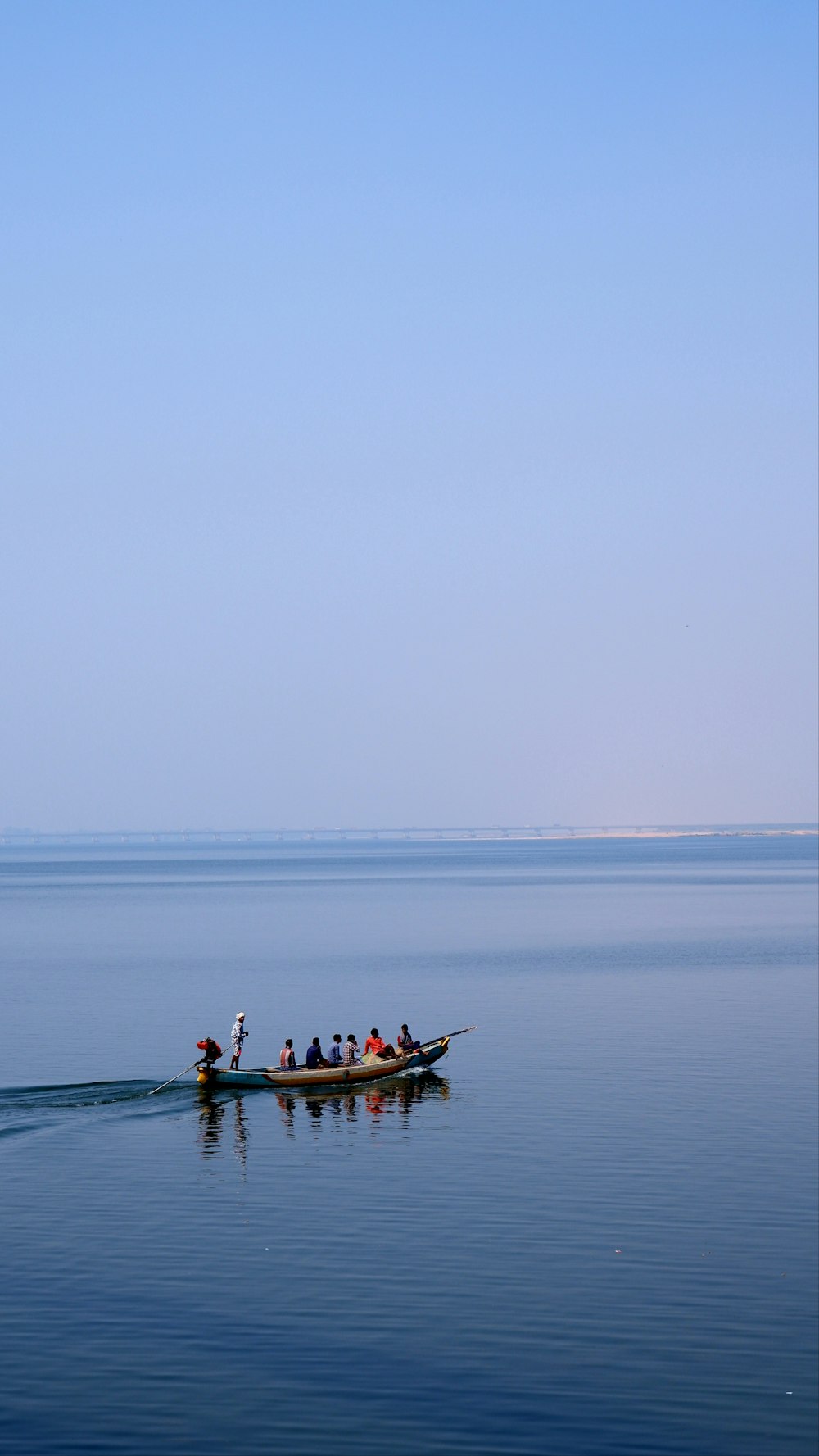 a group of people in a small boat on a large body of water