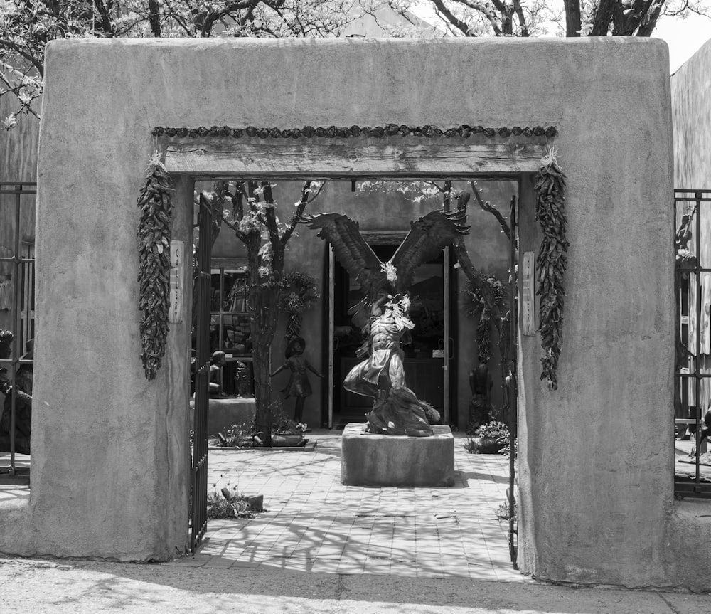 a black and white photo of a statue in a courtyard