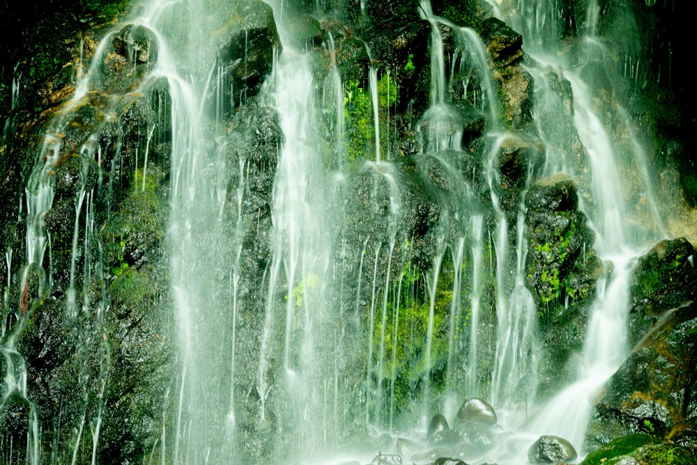 a group of people standing in front of a waterfall