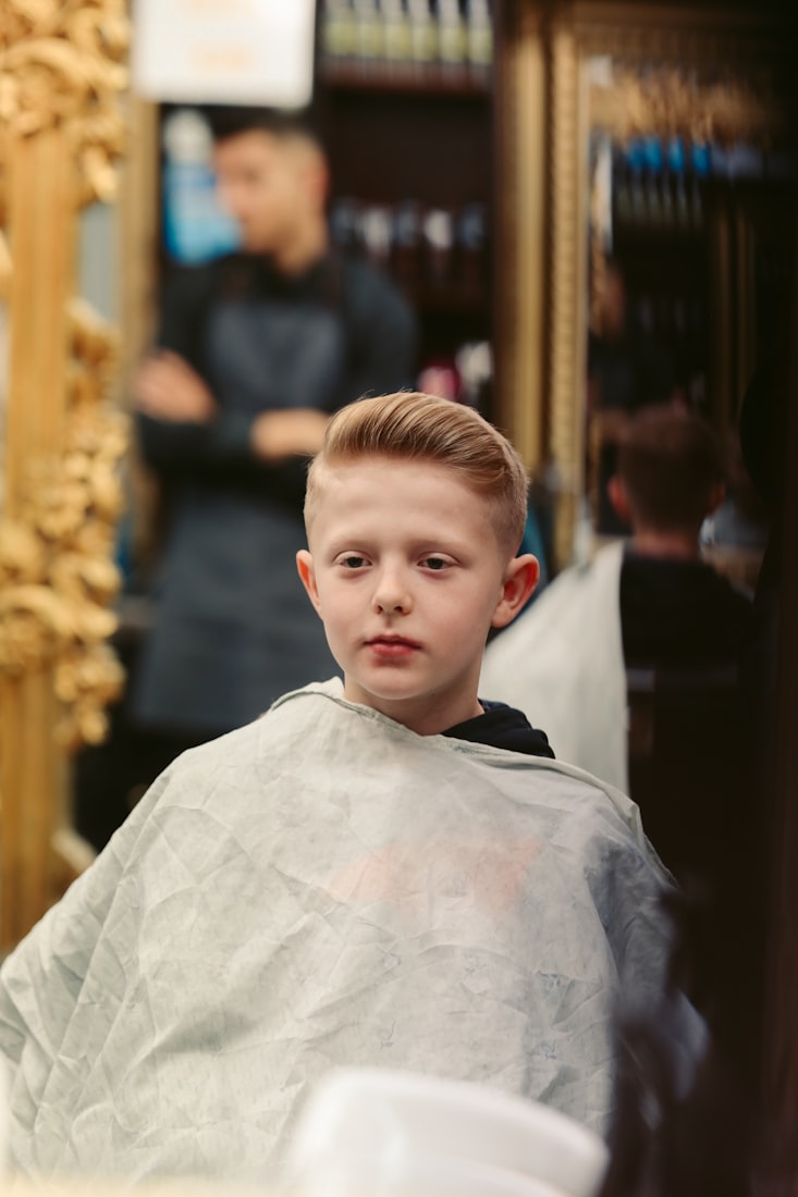 A young client with a fresh cut, cape still on