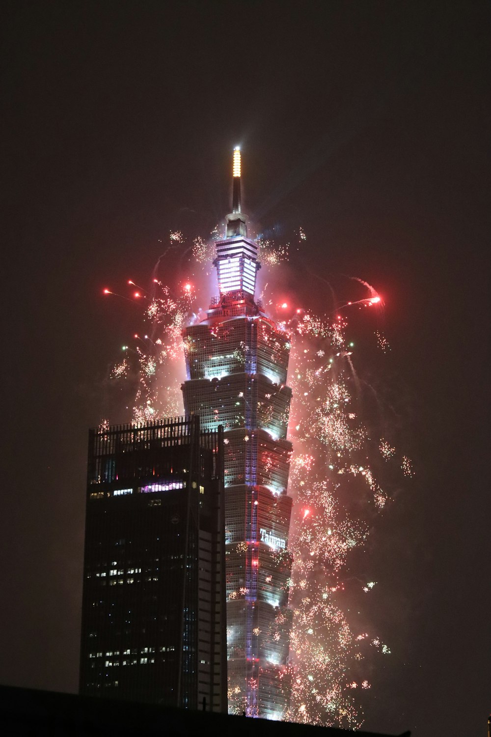 a very tall building with a lot of fireworks in the sky