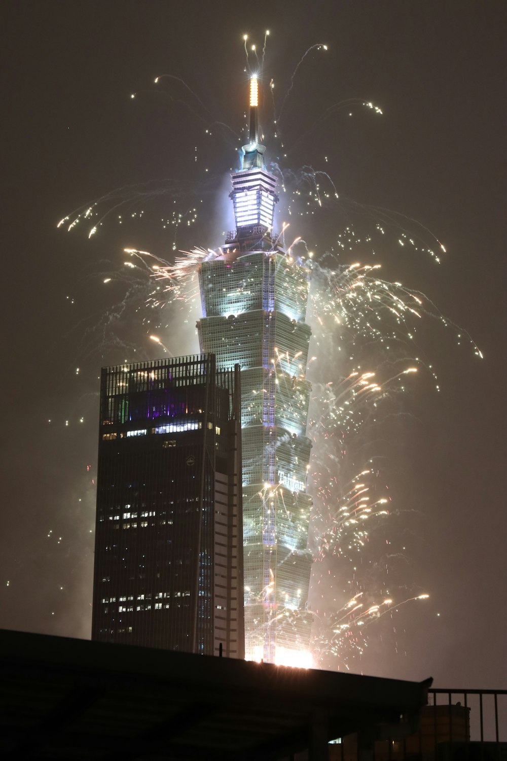 a very tall building with a lot of fireworks in the sky